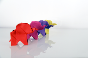 four origami elephants in red purple green and yellow